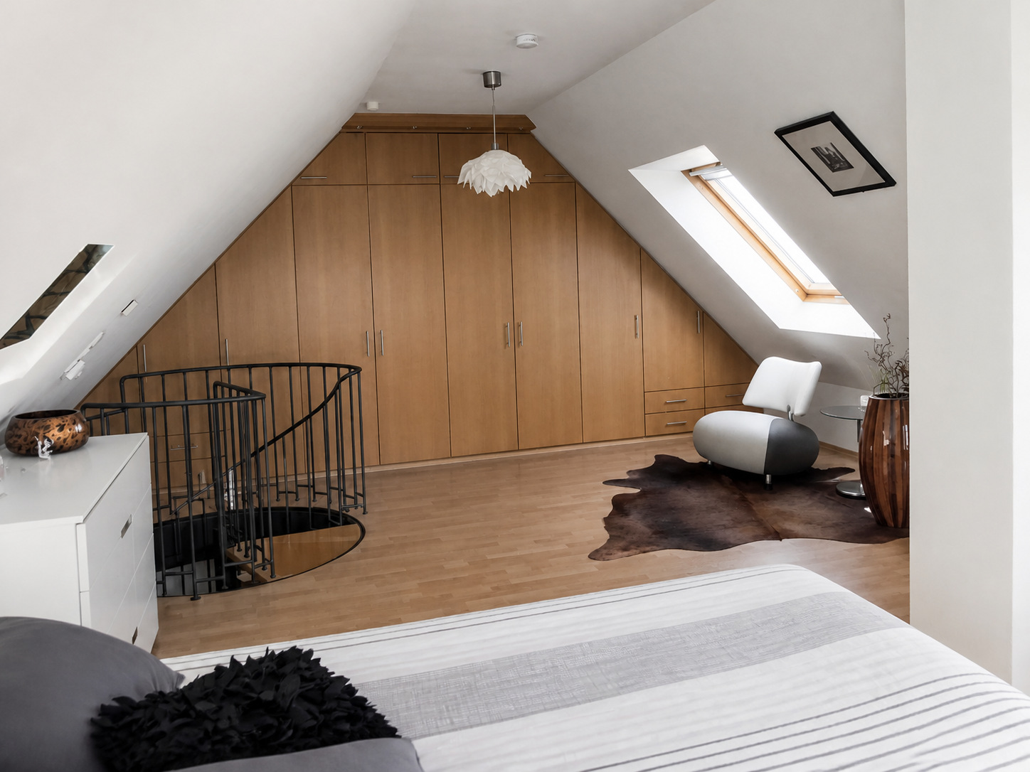 Offenes Dachstudio mit Schrankwand und Wendeltreppe